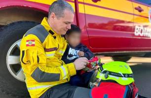 SC: Bombeiro consola criança após carro da família capotar em grave acidente (Foto: Amauri Salles)