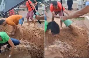 Debaixo de chuva, netos usam as mãos para enterrar avó no Tocantins (Foto: Reprodução)